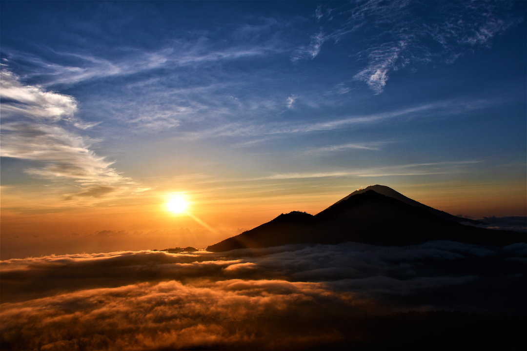 Sunrise over mountains with clouds and a colorful sky.