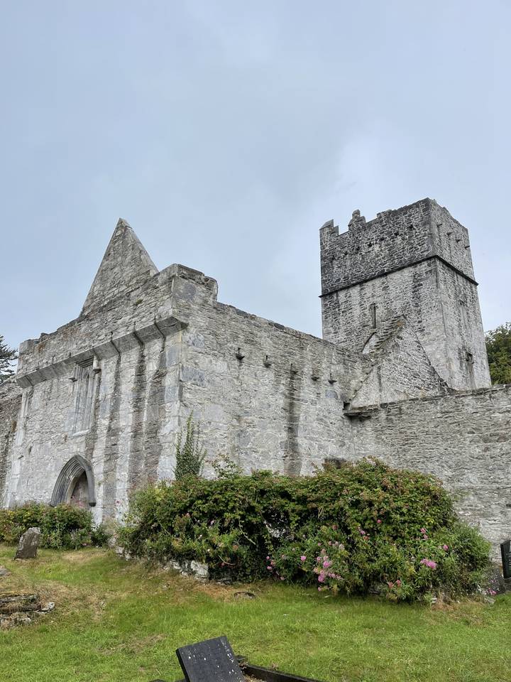 Old stone castle with a lush green lawn.