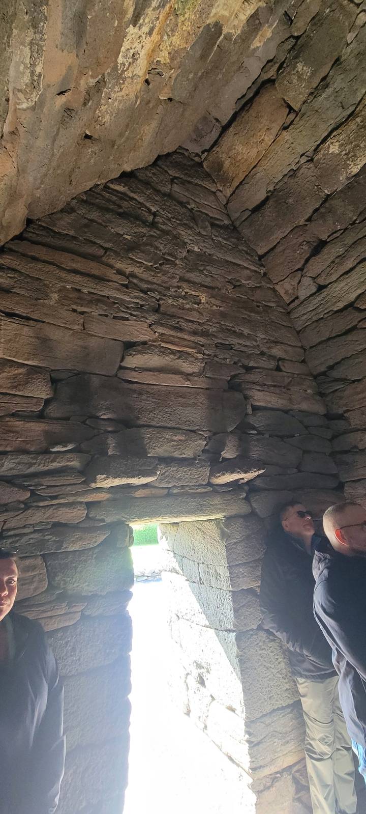 Interior stone passage with tourists observing.