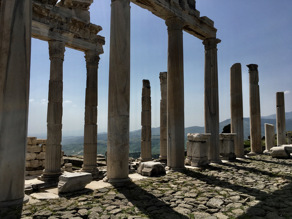 Ancient ruins with tall columns under a bright blue sky.