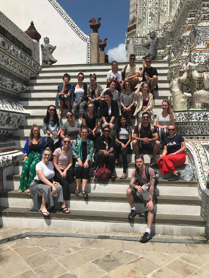 Group of people sitting on steps with intricate decorations.
