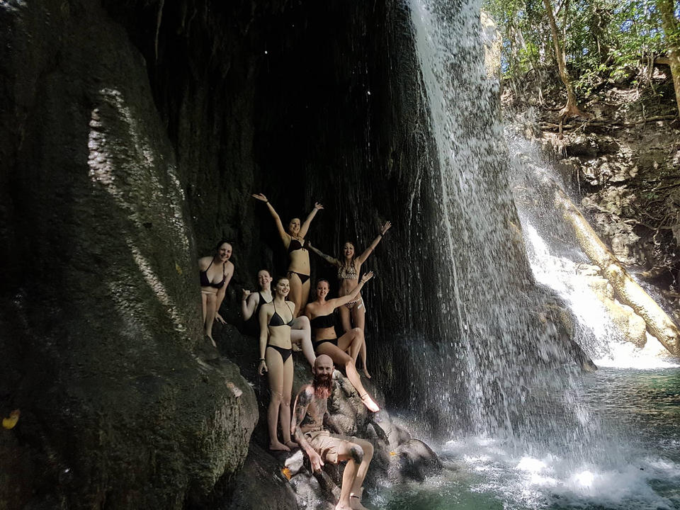 Group of people playing in a waterfall.