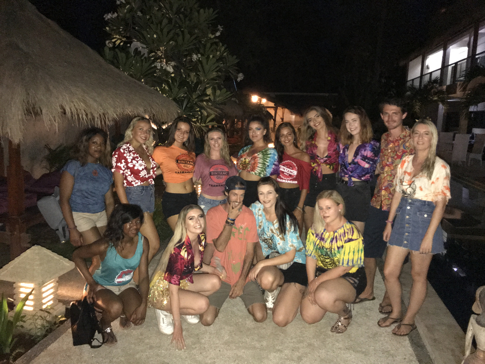 Group of young people posing together at a night event.