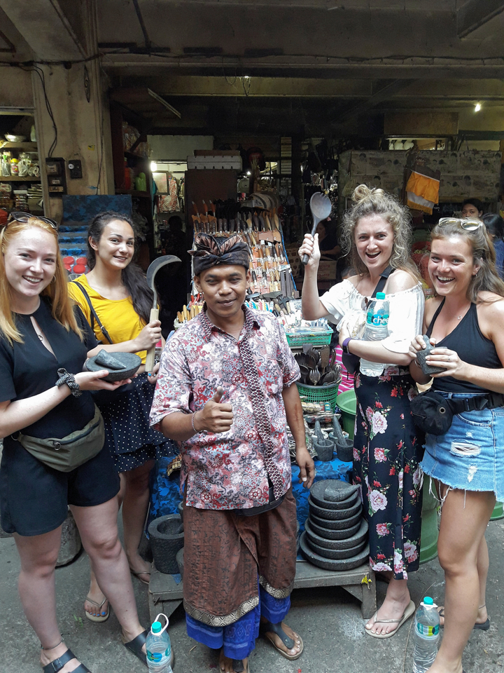 Group of people holding local crafts in a market.