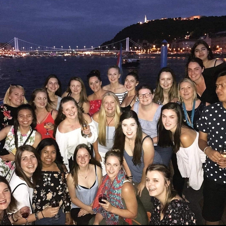 Group photo of people at a nighttime river gathering.