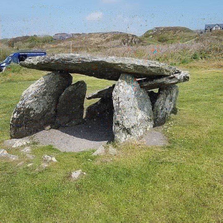 Ancient stone dolmen structure in a grassy area.