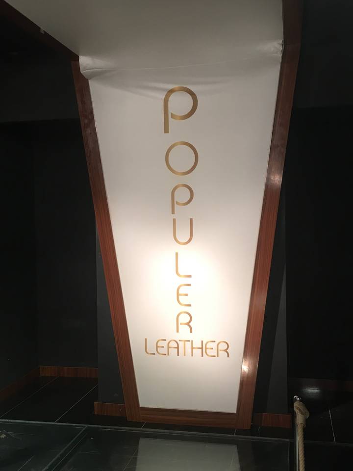 Sideways view of a sign for a leather store.