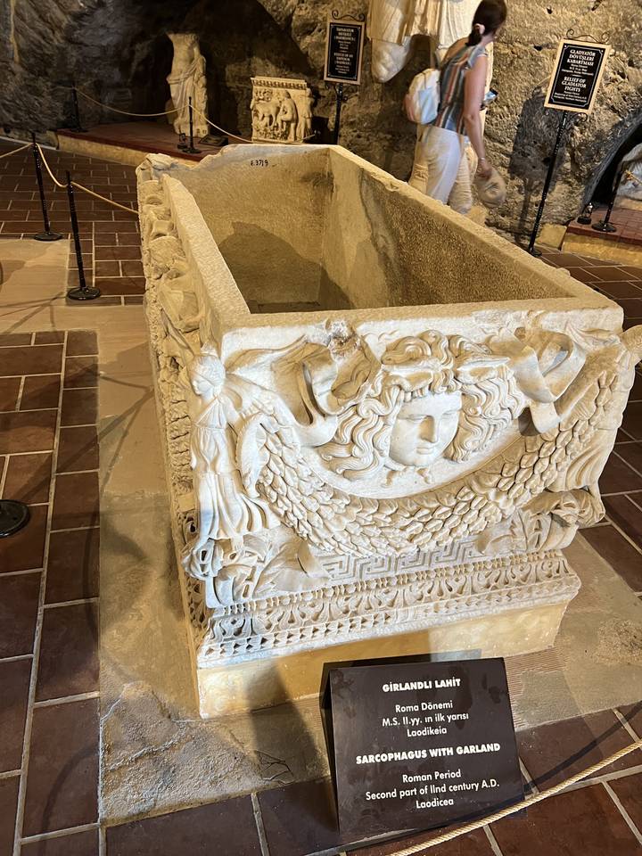 Museum display of an intricately carved sarcophagus.