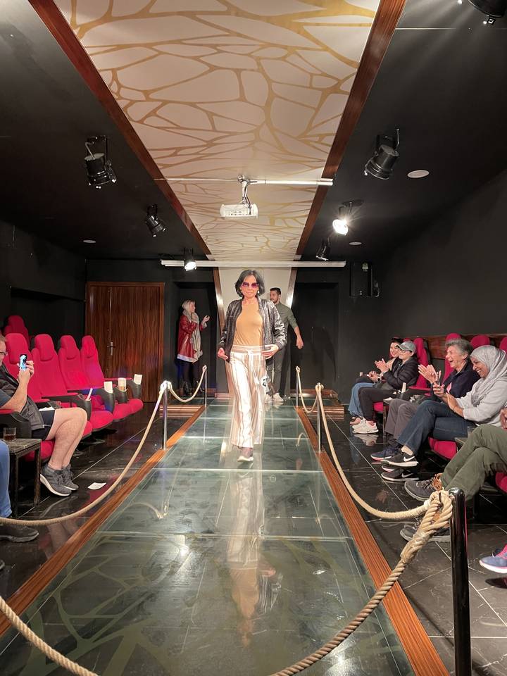 Fashion show with a model walking on a glass ramp.