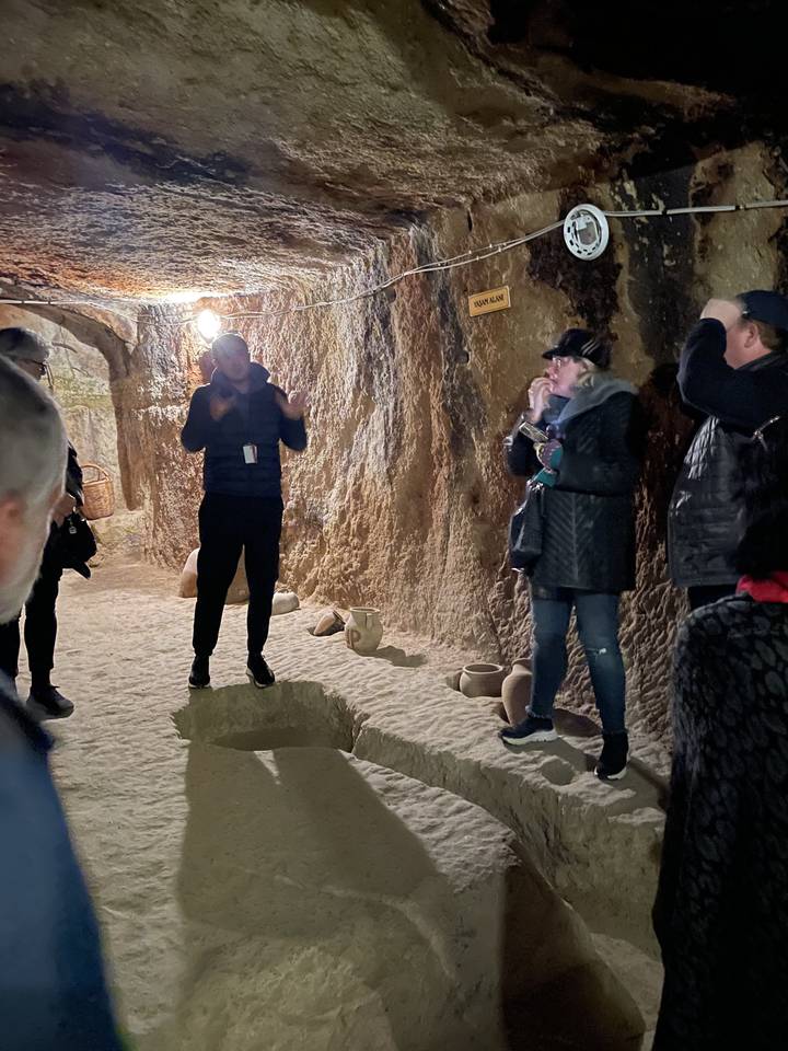 People touring an underground cave setup.