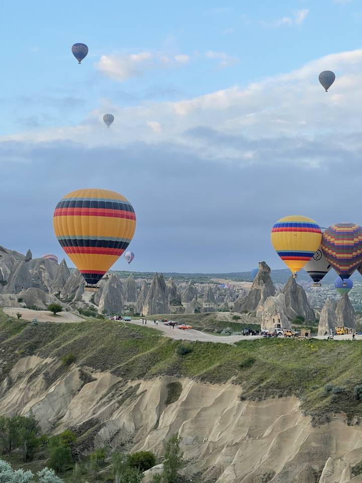 Hot air balloons over rocky landscape.