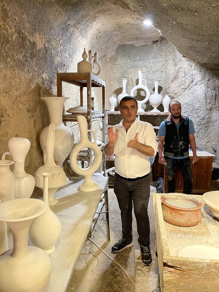 Person showing pottery in a cave.