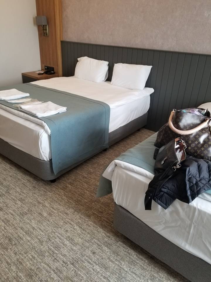 Hotel room with two beds and a bag on top.