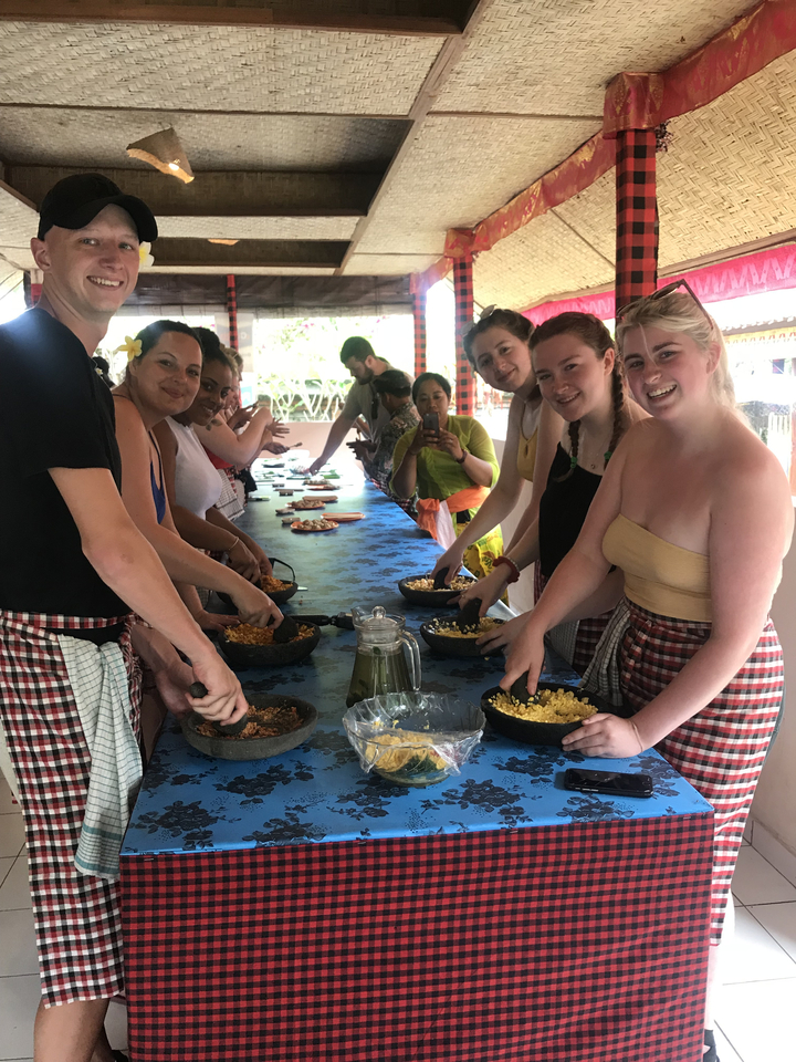 Group participating in a cooking class with smiles and local attire.