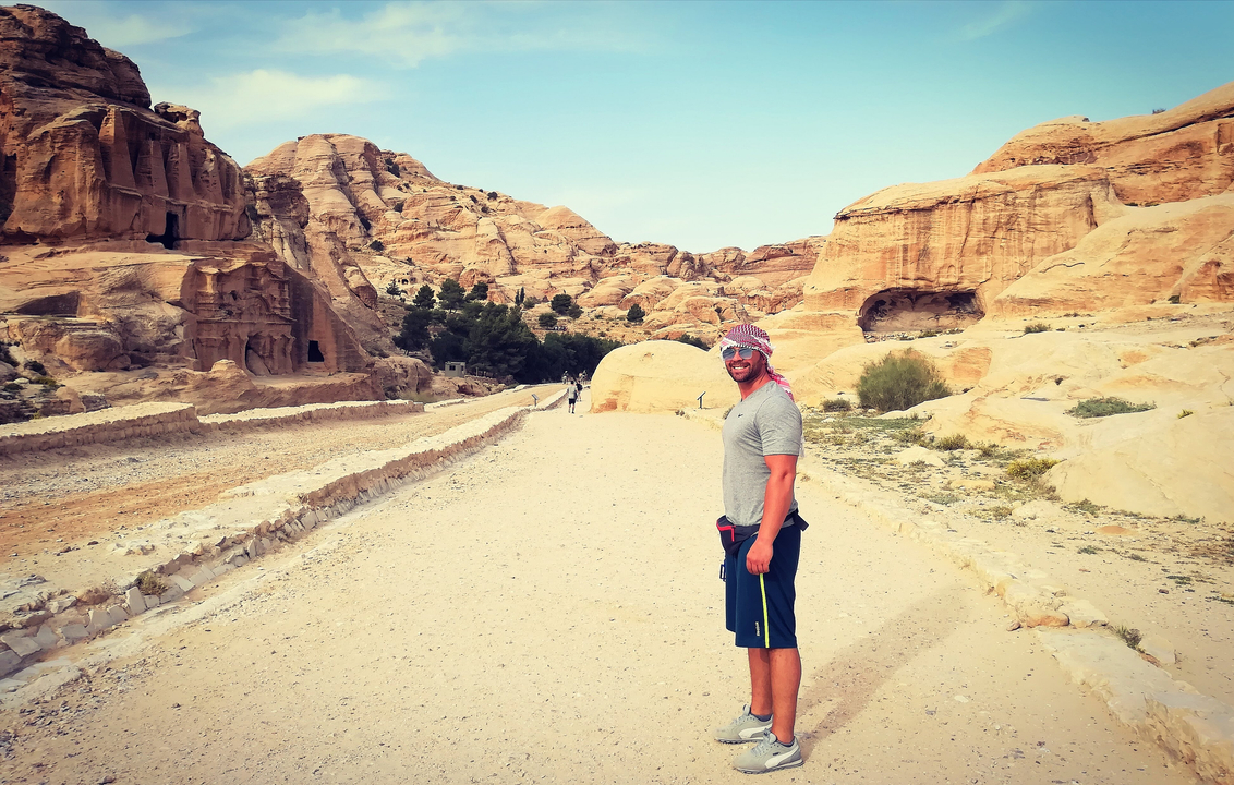 Person standing in a desert landscape with rock formations.