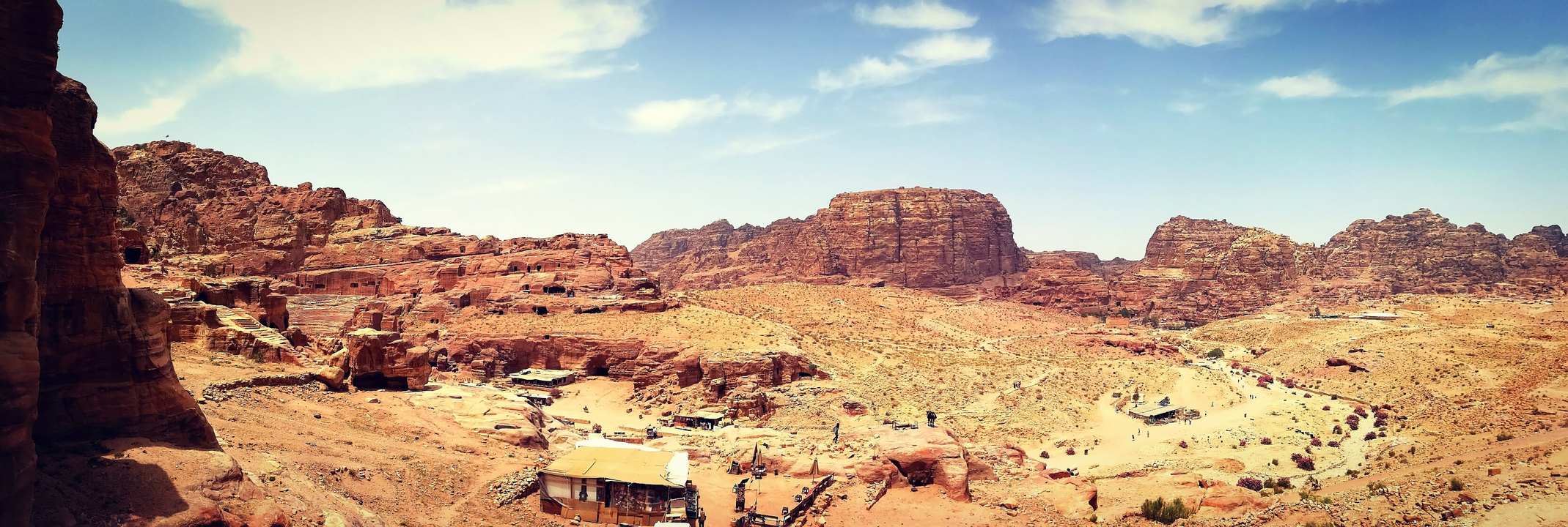 Expansive desert landscape with rocky formations under a clear sky.