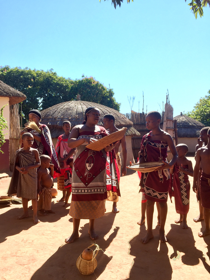 Groupe de personnes portant des vêtements traditionnels dans un cadre culturel.