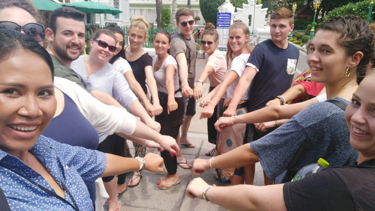 Group of people joining hands in a team gesture.