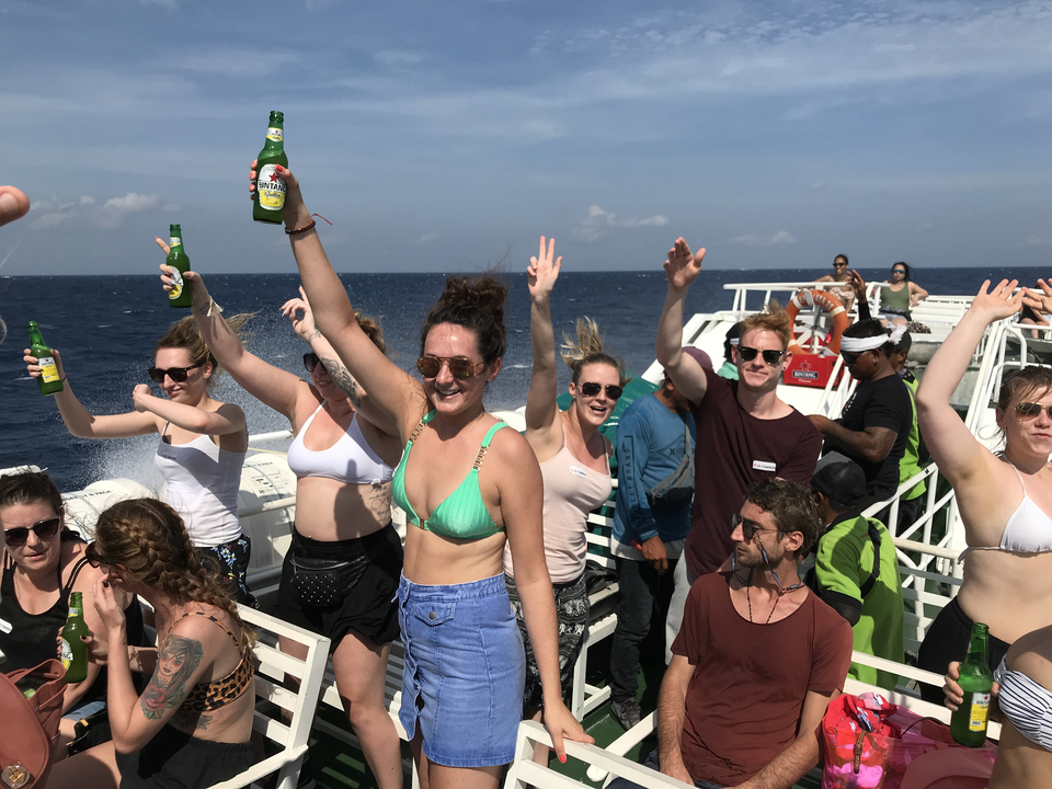 People celebrating on a boat with ocean in the background.