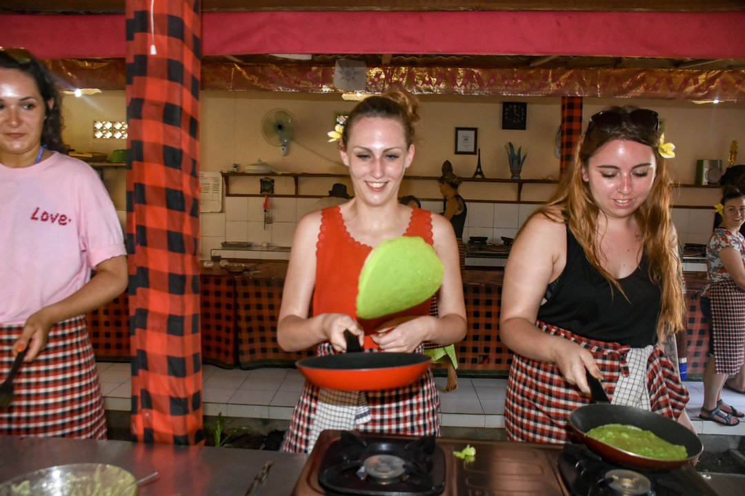 People cooking in an indoor kitchen setting.