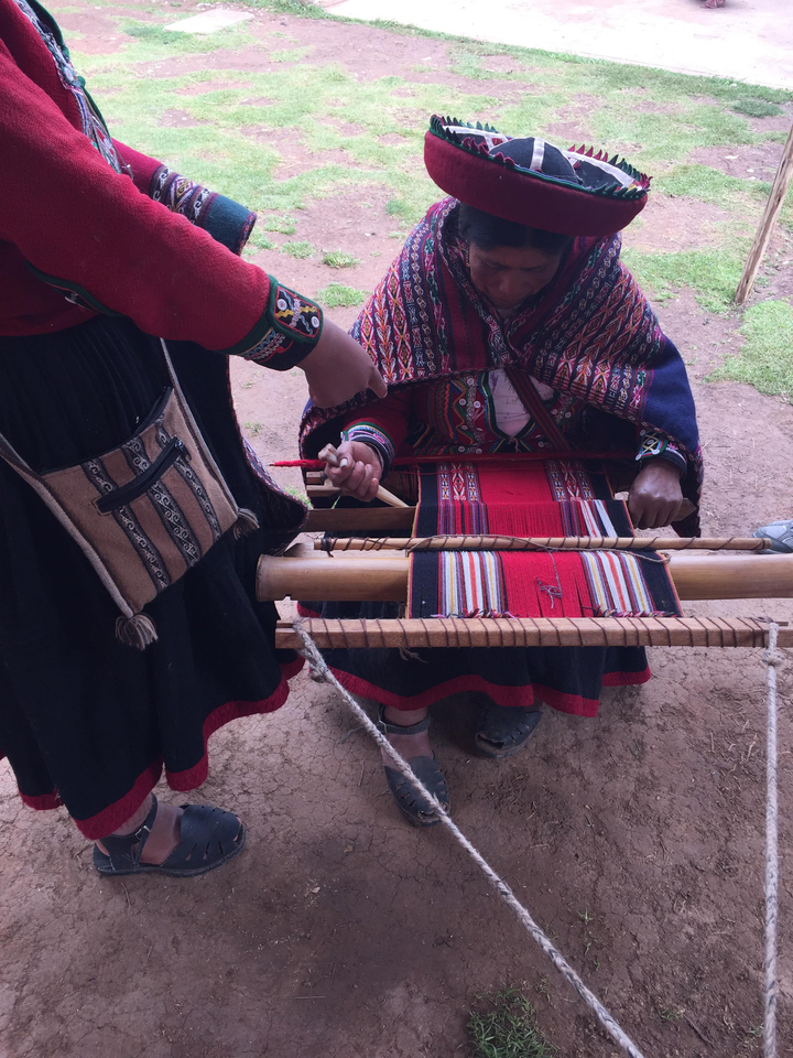 Une personne tissant des textiles traditionnels sur un métier à tisser.
