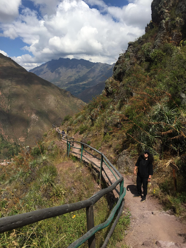 Randonneur sur un sentier de montagne avec une vue panoramique.