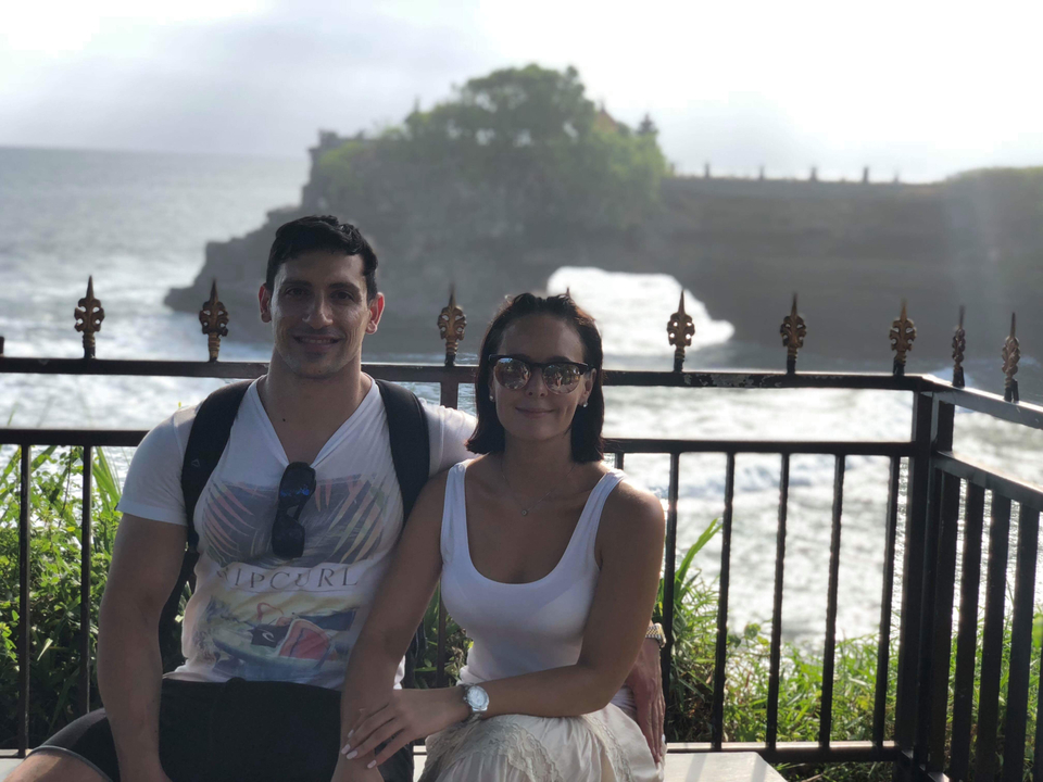 Couple posing in front of a coastal temple.