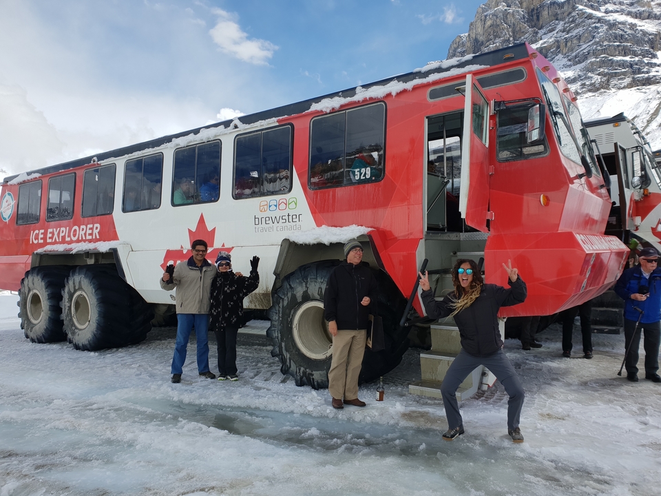 Personnes posant avec un véhicule d'exploration des glaces dans une zone enneigée.