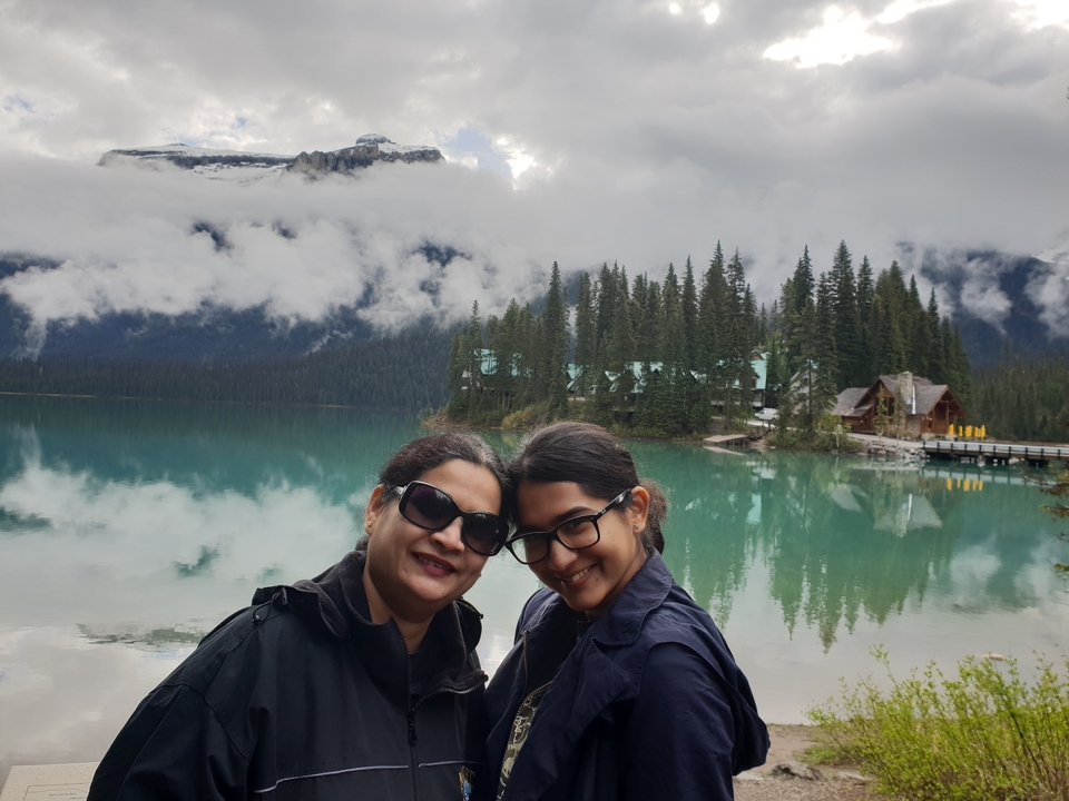 Deux femmes posant avec une vue sur un lac et des montagnes.