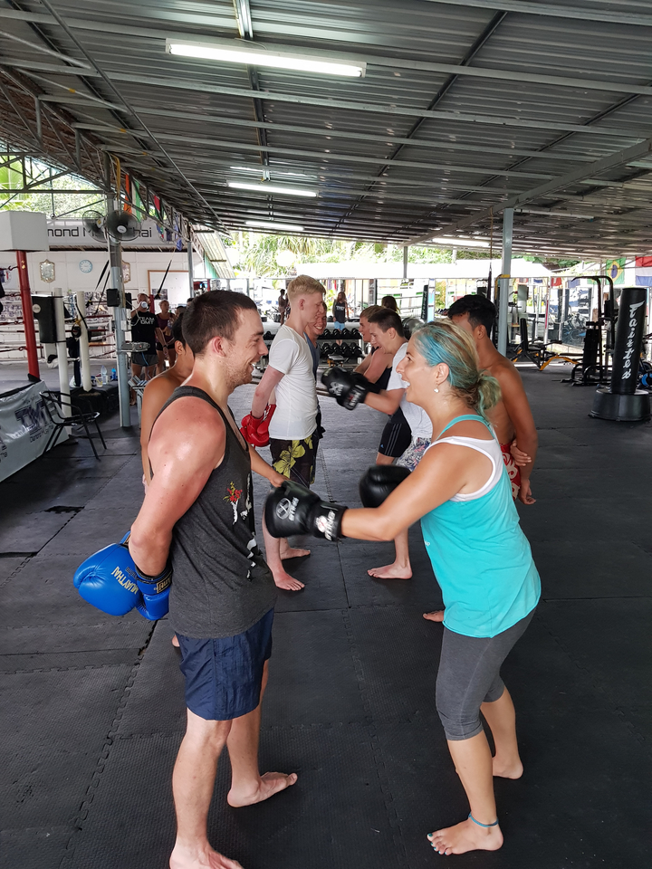 People engaged in a boxing training session in an open gym.