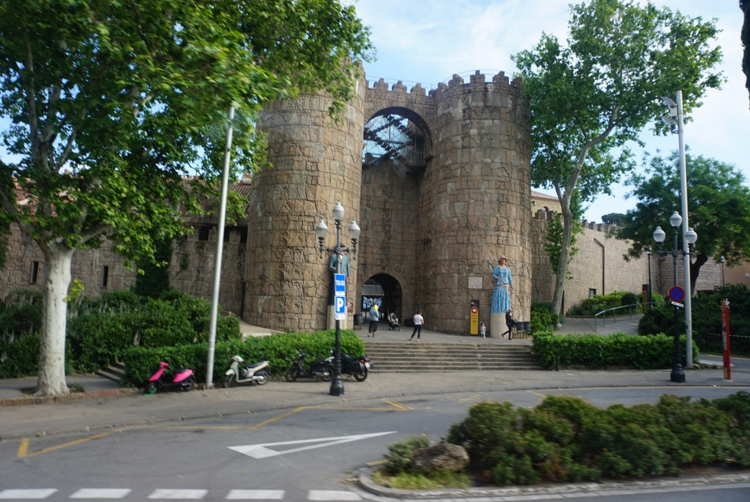 Touristes explorant une porte en pierre d'aspect médiéval.