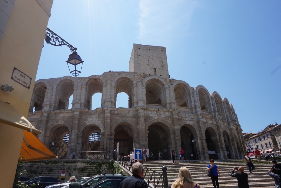 Ancien amphithéâtre romain sous un ciel bleu clair.