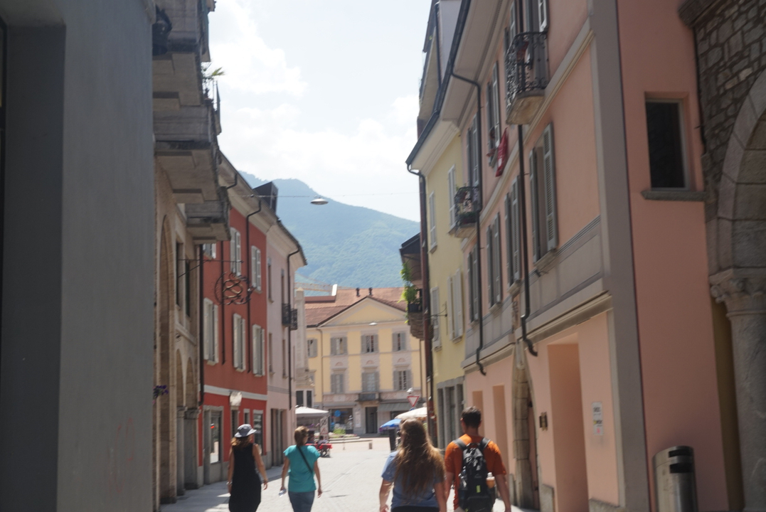 Vue de rue de bâtiments colorés avec des montagnes en arrière-plan.