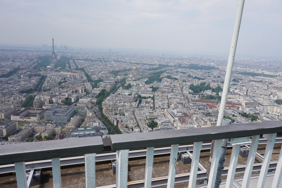 Vue aérienne du paysage urbain de Paris avec la Tour Eiffel au loin.