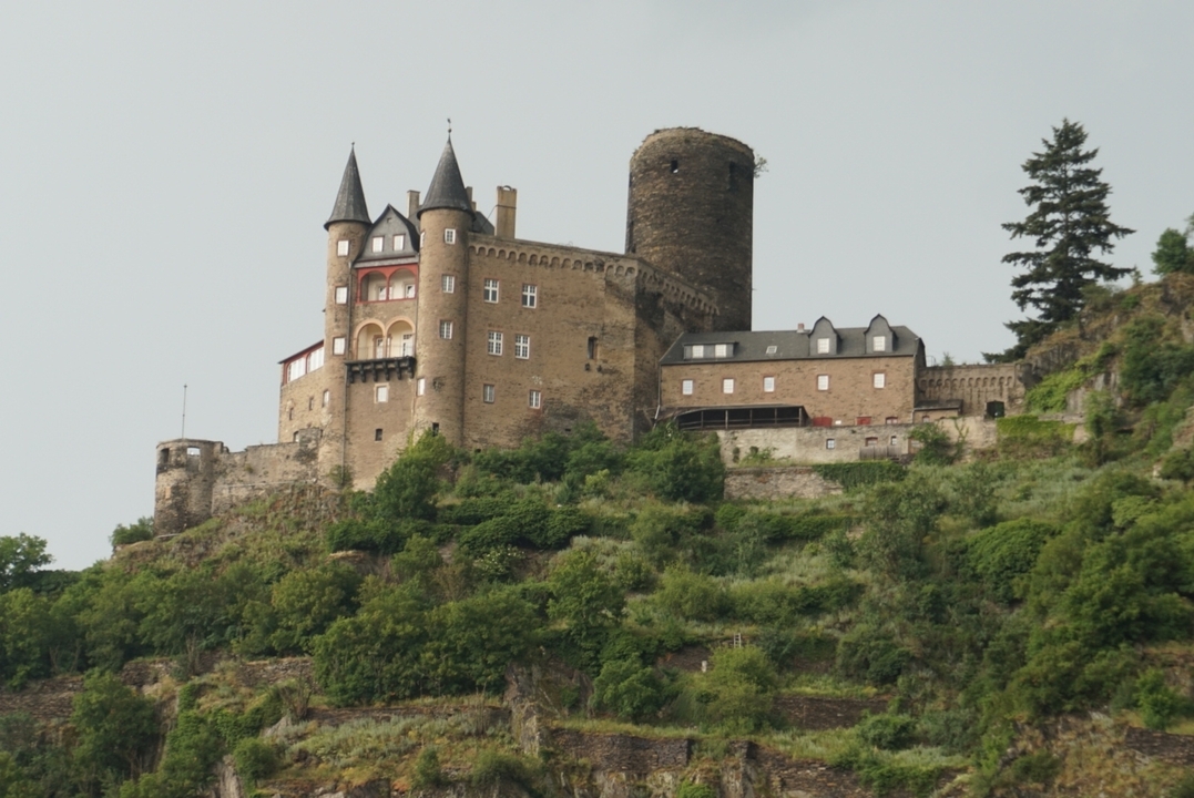 Castle built on a hill, surrounded by lush greenery.