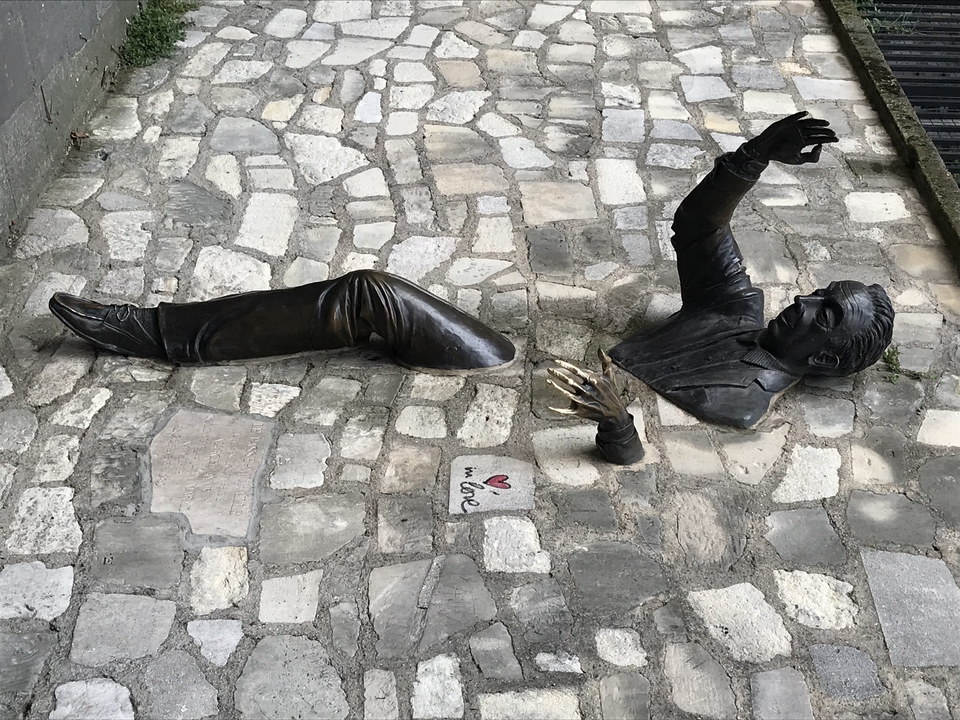 Bronze sculpture embedded in cobblestones.
