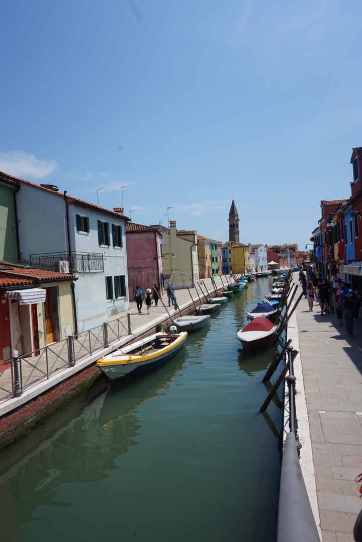 Colorful canal with boats in a picturesque coastal town.
