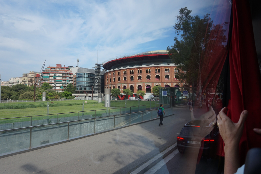 Bâtiment circulaire dans une zone urbaine moderne, vu depuis un bus.