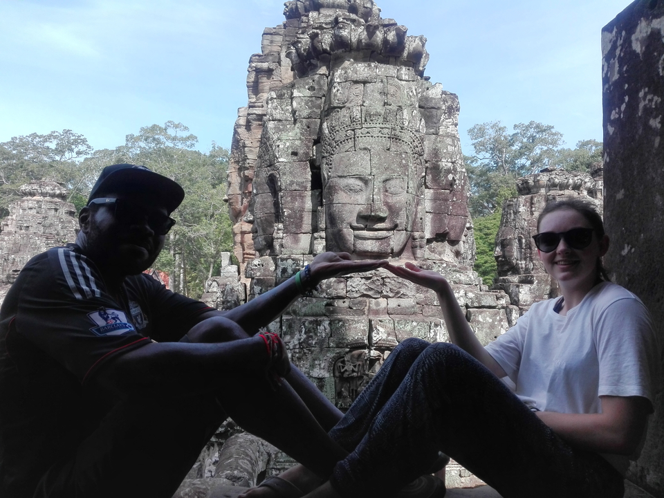 Pair posing with the faces at Bayon temple.