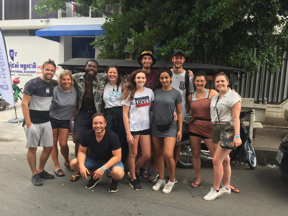 Group of friends standing in front of a tuk-tuk.