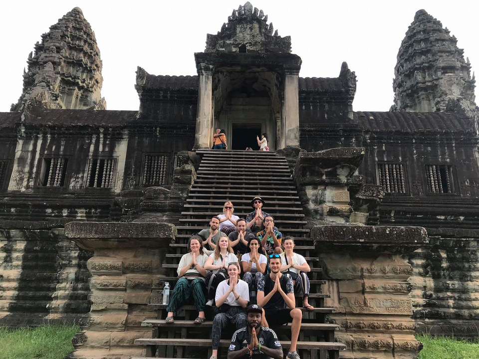 Group posing on the steps of Angkor Wat temple.