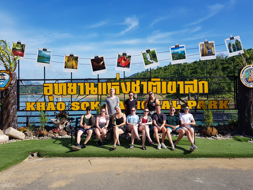 Group posing in front of Khao Sok National Park sign.