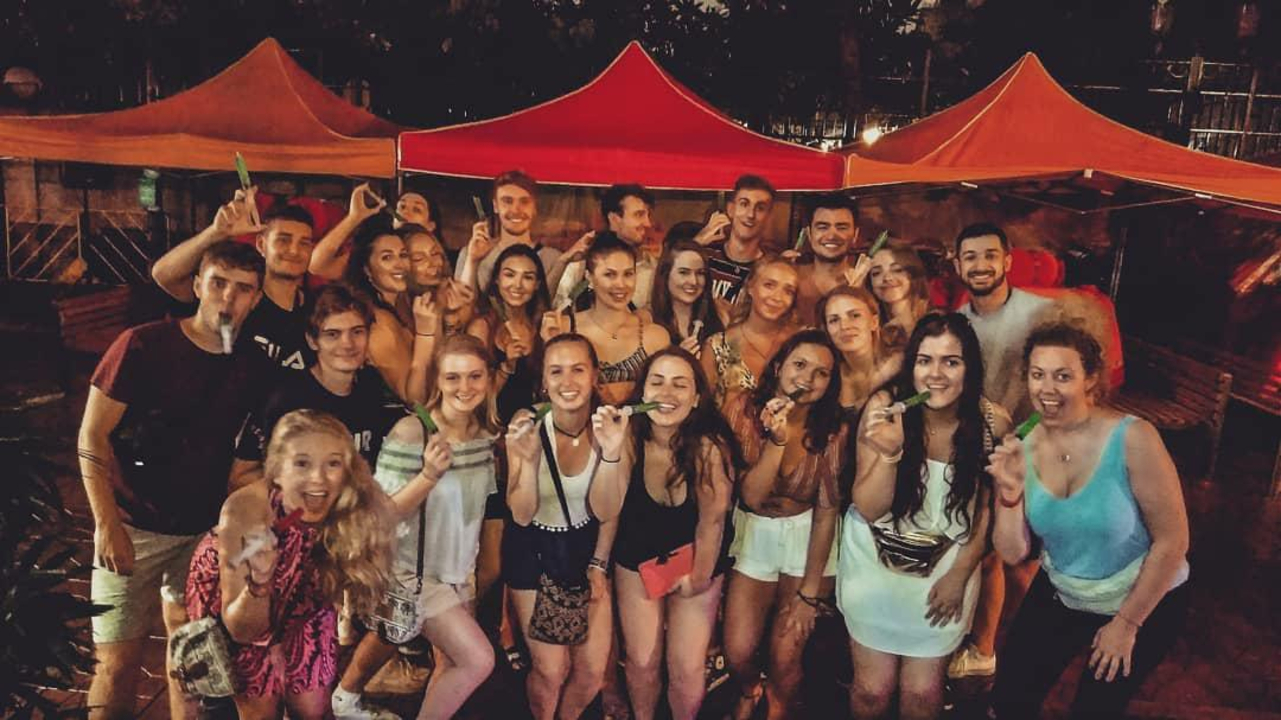 Large group photo at night with various expressions.