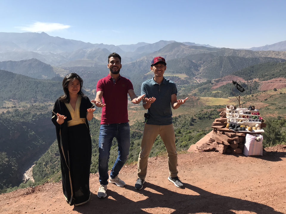 Group posing with a scenic valley and mountains in the background.