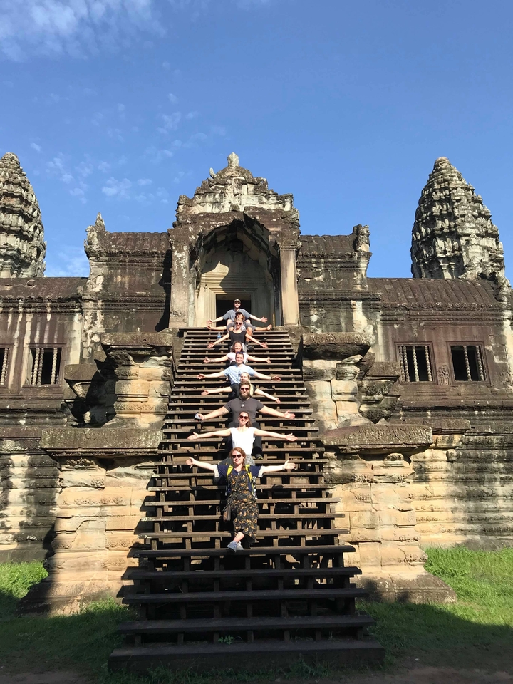 Personnes posant sur les marches d'un ancien temple.