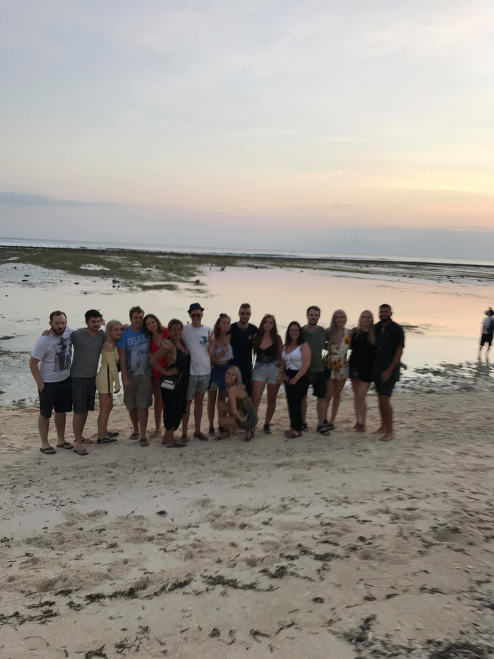 A group of people on a beach with blurry foreground.