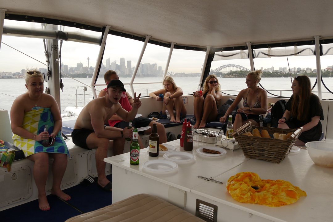 People on a yacht with Sydney Opera House view.