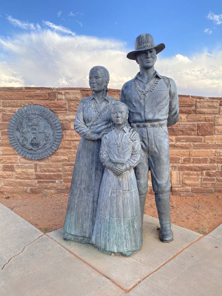 Statues of a family dressed in traditional attire.