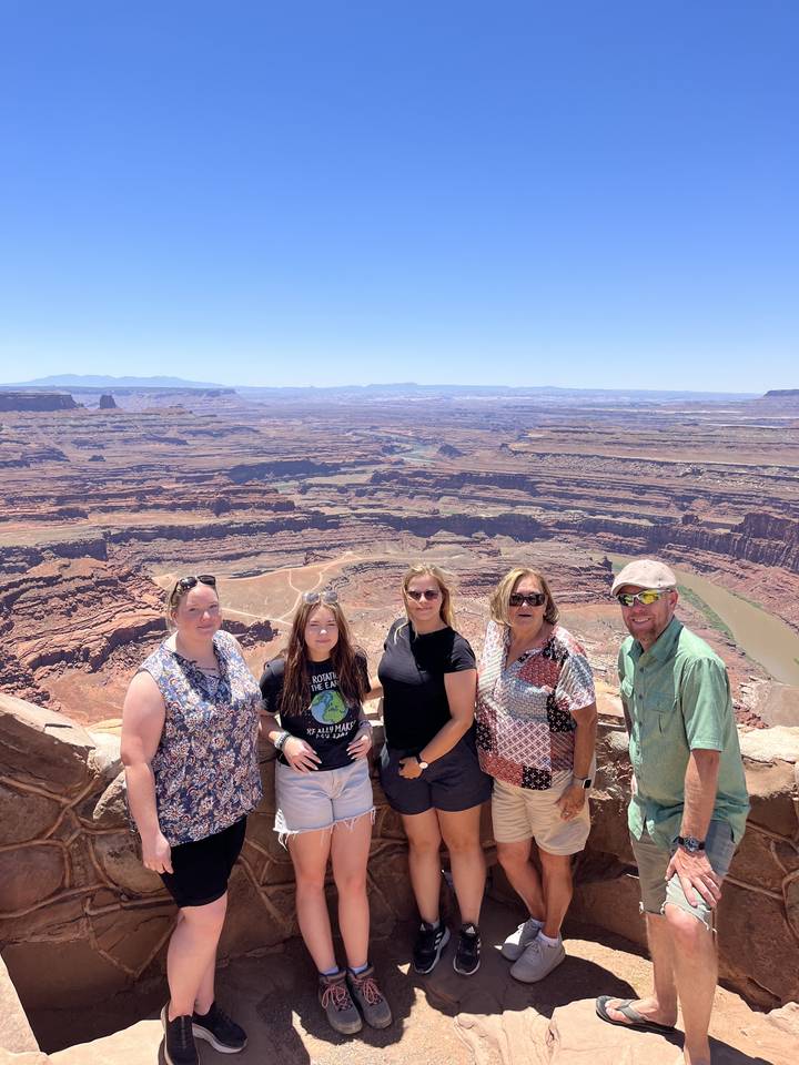 Group of people posing at a canyon viewpoint.