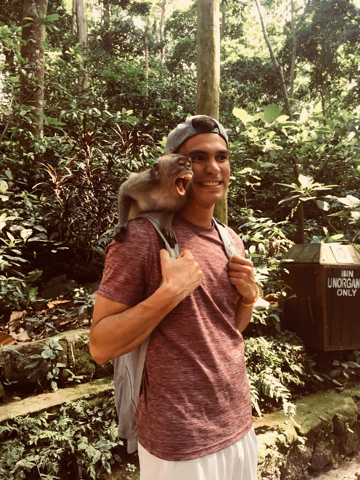 Person posing with a monkey on their shoulder.